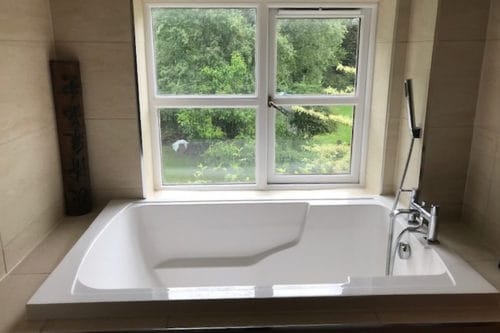 The Nirvana deep soaking tub, installed in a niche in the small en suite bathroom