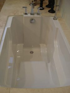 The Nirvana soaking tub's interior, showing its seat and supportive armrests.